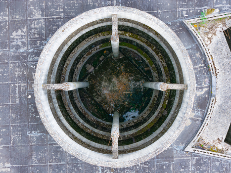 Aerial view of a circular concrete structure with concentric rings and pillars on a tiled rooftop in Leccio Toscana Italy. Aerial view of a circular concrete structure with concentric rings and pillars on a tiled rooftop in Leccio Toscana Italy.