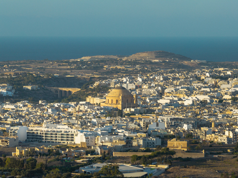 Aerial view of the Rotunda of Mosta a prominent domed church surrounded by the dense urban landscape of Mosta under a clear sky in Mosta Port Region Malta. Aerial view of the Rotunda of Mosta a prominent domed church surrounded by the dense urban landscape of Mosta under a clear sky in Mosta Port Region Malta.