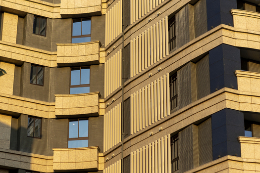 View of the modern facade of a residential building with balconies and architectural slats in warm sunlight Taipei City Taiwan. View of the modern facade of a residential building with balconies and architectural slats in warm sunlight Taipei City Taiwan.