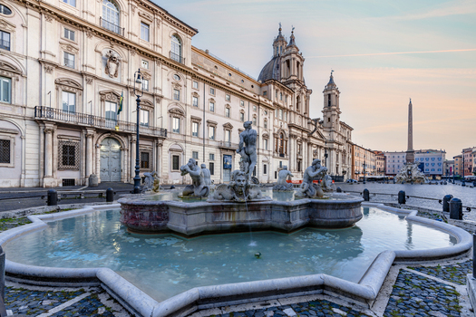 View of Piazza Navona featuring the Fountain of the Moor and the Church of Sant Agnese in Agone with Baroque architecture and stone sculptures in Rome Lazio Italy. View of Piazza Navona featuring the Fountain of the Moor and the Church of Sant Agnese in Agone with Baroque architecture and stone sculptures in Rome Lazio Italy.