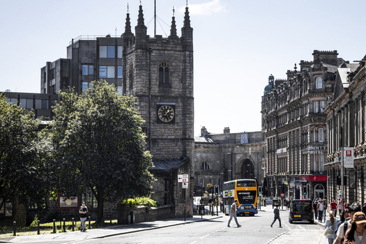 Newcastle upon Tyne United Kingdom 13 July 2026 View of St John the Baptist Church and the County Hotel with pedestrians and a bus on a sunny day. Newcastle upon Tyne United Kingdom 13 July 2026 View of St John the Baptist Church and the County Hotel with pedestrians and a bus on a sunny day.