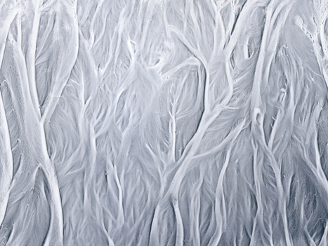 Aerial view of intricate glacial river patterns forming braided channels across the volcanic landscape of Iceland. Aerial view of intricate glacial river patterns forming braided channels across the volcanic landscape of Iceland.