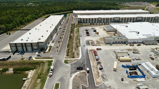 Aerial view of large industrial warehouses and a construction site with heavy machinery and parking lots near Saint Johns Parkway World Golf Village Florida United States. Aerial view of large industrial warehouses and a construction site with heavy machinery and parking lots near Saint Johns Parkway World Golf Village Florida United States.