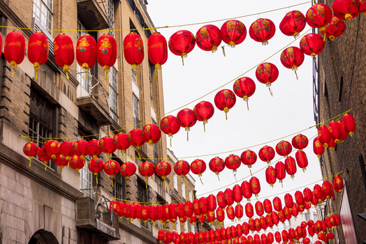 London United Kingdom 12 May 2025 View of red Chinese lanterns hanging in rows across a street in Chinatown against historic brick buildings.