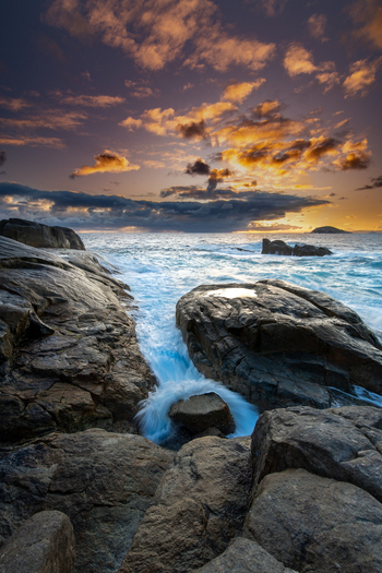 View of the rugged coastline and crashing waves at sunset in Torndirrup National Park Torndirrup Western Australia Australia.