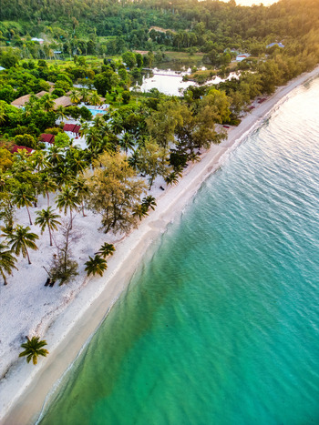 Aerial view of the turquoise sea gently kissing the pristine white sands fringed by verdant trees Preah Sihanouk Sihanoukville Cambodia.