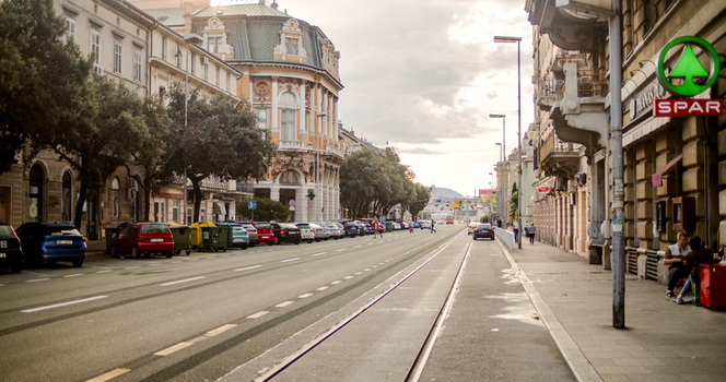 Rijeka Primorje Gorski Kotar Croatia 19 September 2026 View of a street featuring historic architecture tram tracks parked cars and a Spar supermarket sign under a cloudy sky. Rijeka Primorje Gorski Kotar Croatia 19 September 2026 View of a street featuring historic architecture tram tracks parked cars and a Spar supermarket sign under a cloudy sky.