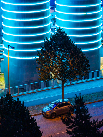 Aerial view of the BTB Heat and Power Plant Adlershof with glowing blue tanks visualizing real time heat energy a car parked on the street and surrounding trees in Berlin Berlin Germany. Aerial view of the BTB Heat and Power Plant Adlershof with glowing blue tanks visualizing real time heat energy a car parked on the street and surrounding trees in Berlin Berlin Germany.