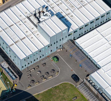 Aerial view of the Data Center at Oxford University with modern rooftops HVAC units a parking area with vehicles bicycle racks and picnic tables in Oxford England United Kingdom. Aerial view of the Data Center at Oxford University with modern rooftops HVAC units a parking area with vehicles bicycle racks and picnic tables in Oxford England United Kingdom.