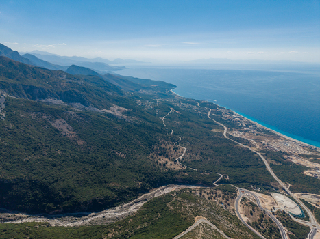 Aerial view of Llogara Pass winding through the Ceraunian Mountains overlooking the Ionian Sea coastline with lush green forests in Llogara Vlore County Albania. Aerial view of Llogara Pass winding through the Ceraunian Mountains overlooking the Ionian Sea coastline with lush green forests in Llogara Vlore County Albania.