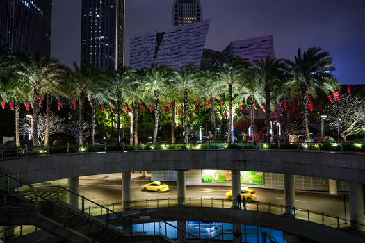 Guangzhou Guangdong Province China 24 February 2024 View of a modern urban street at night with palm trees red lanterns illuminated skyscrapers and yellow taxis on a multi level road. Guangzhou Guangdong Province China 24 February 2024 View of a modern urban street at night with palm trees red lanterns illuminated skyscrapers and yellow taxis on a multi level road.
