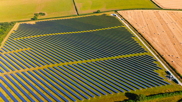 Aerial view of a large solar farm with rows of photovoltaic panels situated in the rural countryside of Dorset England United Kingdom. Aerial view of a large solar farm with rows of photovoltaic panels situated in the rural countryside of Dorset England United Kingdom.