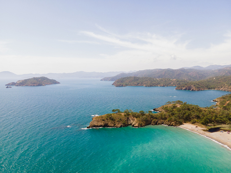 Aerial view of Karaot Beach with turquoise waters rocky coastline and surrounding hills in Fethiye Mugla Turkiye. Aerial view of Karaot Beach with turquoise waters rocky coastline and surrounding hills in Fethiye Mugla Turkiye.