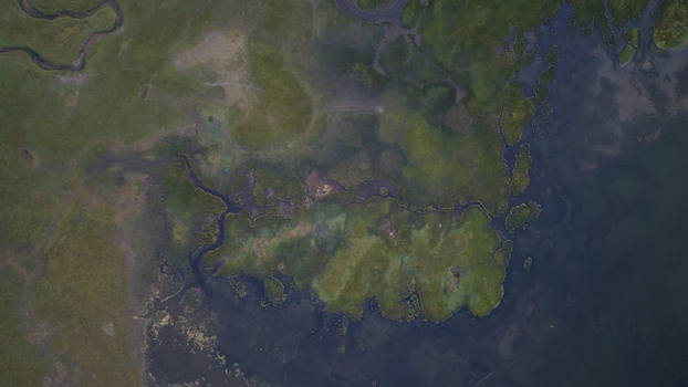 Aerial view of Song Kul lake with winding streams and marshy green shoreline Naryn Region Kyrgyzstan. Aerial view of Song Kul lake with winding streams and marshy green shoreline Naryn Region Kyrgyzstan.