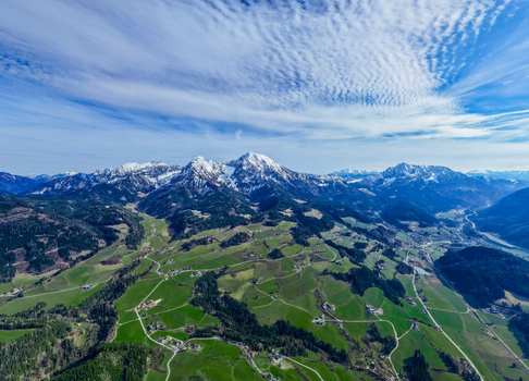 Aerial view of the verdant Windischgarsten valley floor meeting snow capped peaks under a patterned sky Windischgarsten Upper Austria Austria. Aerial view of the verdant Windischgarsten valley floor meeting snow capped peaks under a patterned sky Windischgarsten Upper Austria Austria.