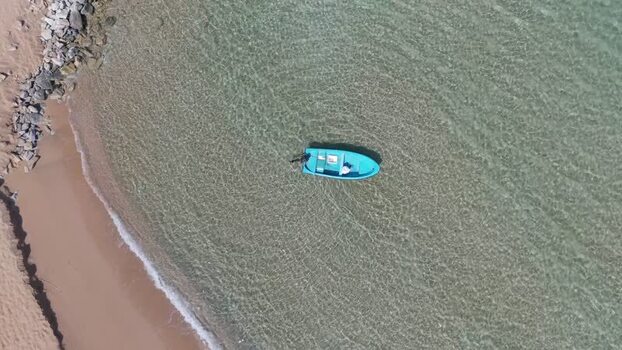 Aerial view of a blue boat in clear water Northern Cyprus.