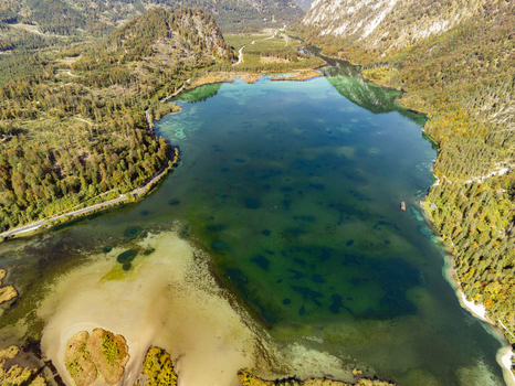 Aerial view of a clear mountain lake surrounded by dense pine forests and steep rocky slopes in Rottenbach Bayern Germany. Aerial view of a clear mountain lake surrounded by dense pine forests and steep rocky slopes in Rottenbach Bayern Germany.