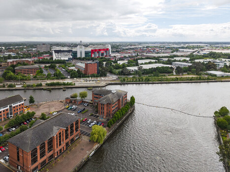 Aerial view of Old Trafford stadium and surrounding industrial buildings along the Manchester Ship Canal in Stretford England United Kingdom.