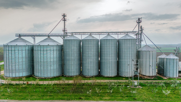 Aerial view of gleaming metallic silos stand tall against the muted green of the surrounding landscape a testament to agricultural industry Sremska Mitrovica Vojvodina Serbia. Aerial view of gleaming metallic silos stand tall against the muted green of the surrounding landscape a testament to agricultural industry Sremska Mitrovica Vojvodina Serbia.
