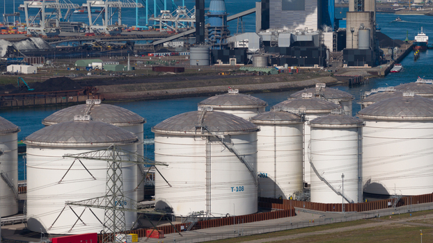 Aerial view of the Port of Rotterdam featuring large industrial storage tanks cargo cranes and a power plant along the waterfront in Rotterdam Zuid Holland Netherlands. Aerial view of the Port of Rotterdam featuring large industrial storage tanks cargo cranes and a power plant along the waterfront in Rotterdam Zuid Holland Netherlands.