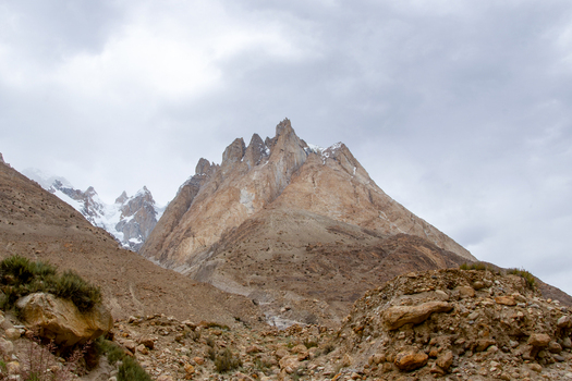 View of the rugged rocky terrain and towering snow capped peaks of the Karakoram range near K2 Base Camp in Gilgit Pakistan. View of the rugged rocky terrain and towering snow capped peaks of the Karakoram range near K2 Base Camp in Gilgit Pakistan.