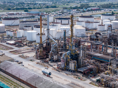 Aerial view of the Milnerton oil refinery featuring large storage tanks tall distillation towers complex piping systems and industrial infrastructure Cape Town Western Cape South Africa. Aerial view of the Milnerton oil refinery featuring large storage tanks tall distillation towers complex piping systems and industrial infrastructure Cape Town Western Cape South Africa.