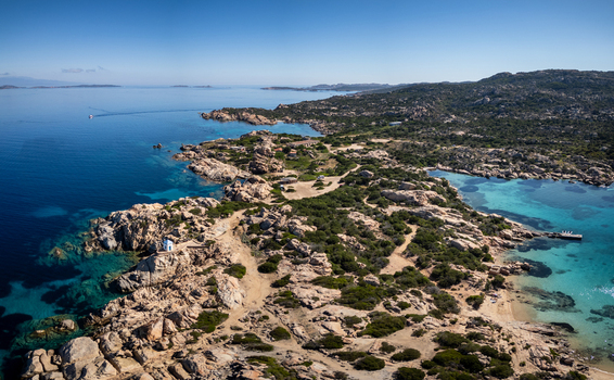 Aerial view of the Altare della Madonnetta chapel perched on a rocky cliff overlooking turquoise waters and rugged Mediterranean coastline La Maddalena Sardinia Italy. Aerial view of the Altare della Madonnetta chapel perched on a rocky cliff overlooking turquoise waters and rugged Mediterranean coastline La Maddalena Sardinia Italy.