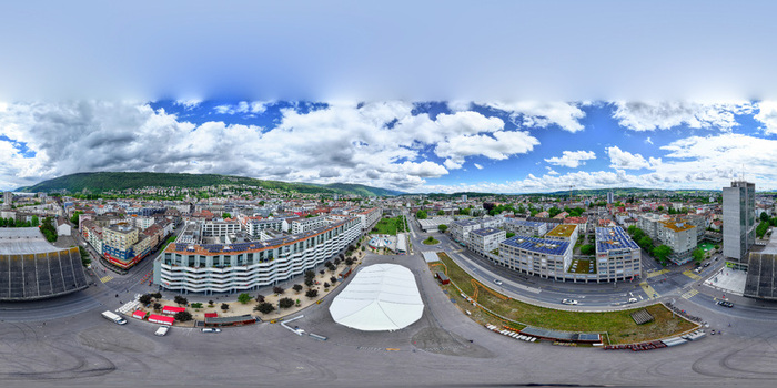 Aerial view of modern urban architecture a large white event tent in a central square and surrounding hills under a cloudy sky in Biel Bienne Canton of Bern Switzerland. Aerial view of modern urban architecture a large white event tent in a central square and surrounding hills under a cloudy sky in Biel Bienne Canton of Bern Switzerland.