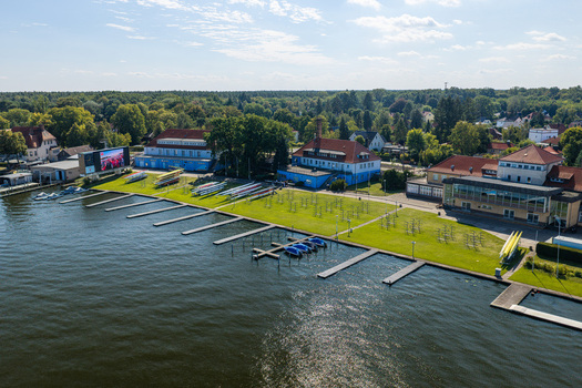 Aerial view of Berlin Grunau Regatta Course with rowing boats on the grass docks and historic buildings along the river in Berlin Berlin Germany. Aerial view of Berlin Grunau Regatta Course with rowing boats on the grass docks and historic buildings along the river in Berlin Berlin Germany.