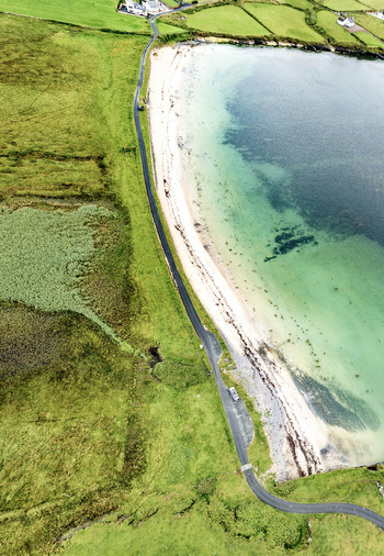 Aerial view of St John s Point Beach with its sandy shore turquoise waters and surrounding green fields in Dunkineely County Donegal Ireland.