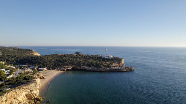 Aerial view of the Farol de Alfanzina lighthouse on the rocky cliffs overlooking the Atlantic Ocean near Ferragudo Faro District Portugal.