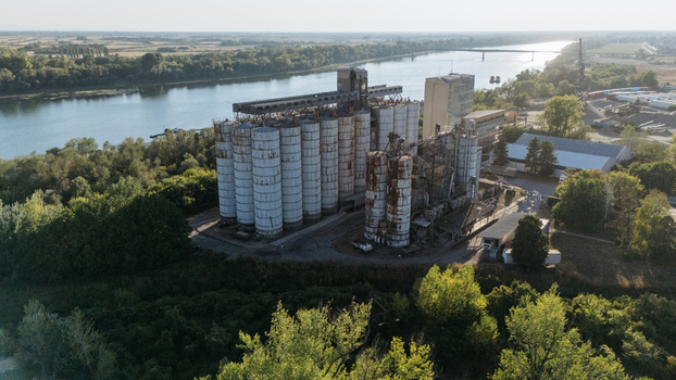Aerial view of industrial grain silos situated along the Sava River surrounded by lush greenery and trees in Sremska Mitrovica Vojvodina Serbia. Aerial view of industrial grain silos situated along the Sava River surrounded by lush greenery and trees in Sremska Mitrovica Vojvodina Serbia.