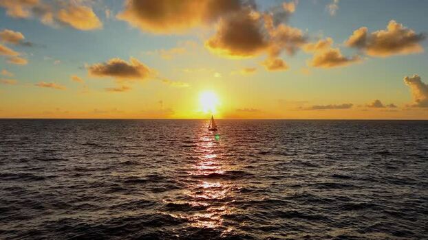 Aerial view of a sailboat at sunset on the ocean United States. Aerial view of a sailboat at sunset on the ocean United States.