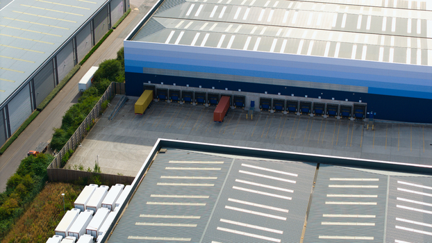 Aerial view of a large logistics hub featuring industrial warehouses loading bays and parked HGVs in Bedford England United Kingdom. Aerial view of a large logistics hub featuring industrial warehouses loading bays and parked HGVs in Bedford England United Kingdom.