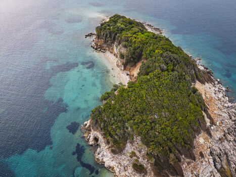 Aerial view of the lush green Ksamil islands surrounded by turquoise and deep blue Ionian Sea waters featuring rocky coastlines and dense vegetation Ksamil Vlore County Albania. Aerial view of the lush green Ksamil islands surrounded by turquoise and deep blue Ionian Sea waters featuring rocky coastlines and dense vegetation Ksamil Vlore County Albania.
