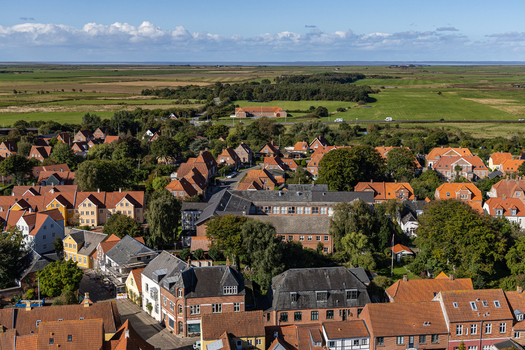 View of the historic red tiled rooftops and traditional architecture of the old town under a bright blue sky in Ribe Denmark. View of the historic red tiled rooftops and traditional architecture of the old town under a bright blue sky in Ribe Denmark.