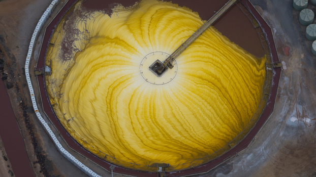 Aerial view of a large circular salt production pile with vibrant yellow mineral patterns and industrial infrastructure in Kalbarri Western Australia Australia. Aerial view of a large circular salt production pile with vibrant yellow mineral patterns and industrial infrastructure in Kalbarri Western Australia Australia.
