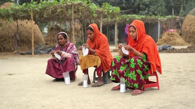 View of women winding thread in a rural setting Bangladesh. View of women winding thread in a rural setting Bangladesh.
