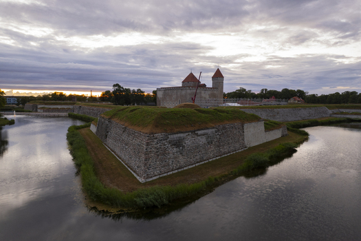 Aerial view of Kuressaare Castle surrounded by a moat and historic stone fortifications under a cloudy sunset sky in Kuressaare Saare County Estonia.