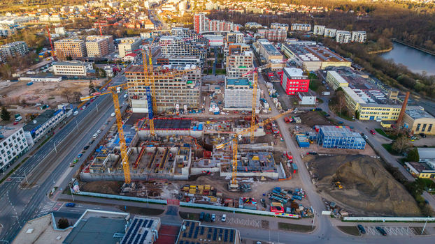 Aerial view of a construction site with towering cranes against a backdrop of buildings and river Prague 9 Prague Czechia. Aerial view of a construction site with towering cranes against a backdrop of buildings and river Prague 9 Prague Czechia.