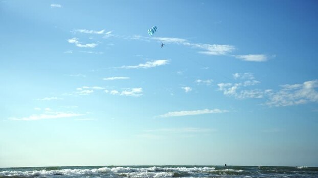 View of a person parasailing over the ocean waves in Bangladesh.