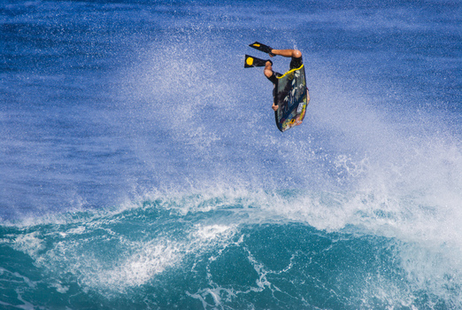 View of a bodyboarder performing an aerial maneuver on a powerful wave at the North Shore in Waialua Hawaii United States.