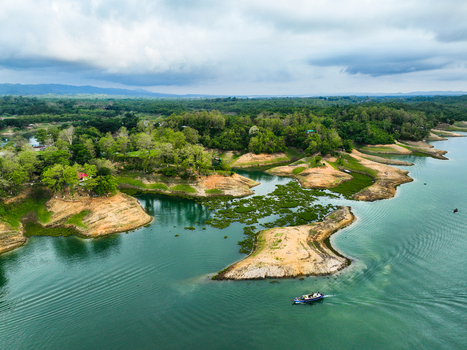 Rangamati Hill District Chittagong Division Bangladesh 18 May 2024 Aerial view of Kaptai Lake with lush islands turquoise water and a small boat navigating the landscape.