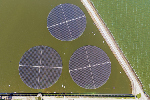 Aerial view of three circular floating solar islands on the water surface near the coast in Andijk Noord Holland Netherlands. Aerial view of three circular floating solar islands on the water surface near the coast in Andijk Noord Holland Netherlands.