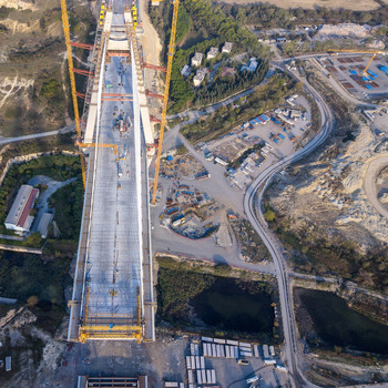 Aerial view of the construction of the Yavuz Sultan Selim Bridge showing the massive suspension towers bridge deck cranes and surrounding industrial site in Istanbul Istanbul Turkiye.