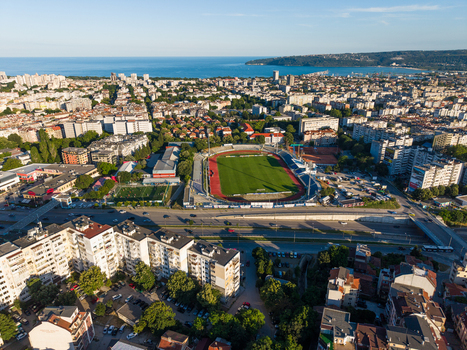 Varna Bulgaria 23 June 2026 Aerial view of Spartak Stadium surrounded by urban residential buildings green trees and roads with the Black Sea in the background.