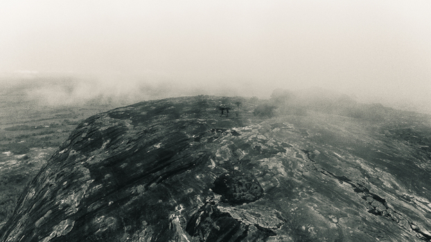 Aerial view of a rugged rocky landscape shrouded in mist revealing stark textures and tones under an ethereal sky Oyo Oyo Nigeria. Aerial view of a rugged rocky landscape shrouded in mist revealing stark textures and tones under an ethereal sky Oyo Oyo Nigeria.