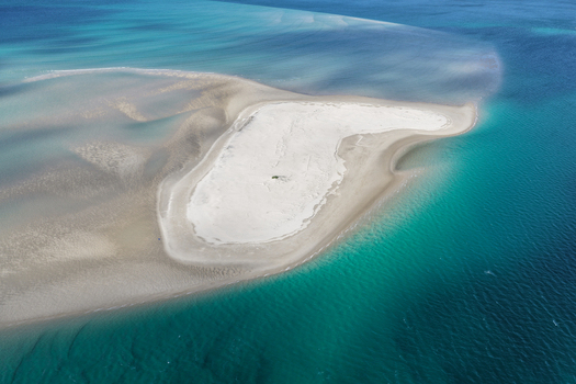 Aerial view of a white sandbank surrounded by turquoise and deep blue waters of Moreton Bay near Amity Point Queensland Australia. Aerial view of a white sandbank surrounded by turquoise and deep blue waters of Moreton Bay near Amity Point Queensland Australia.