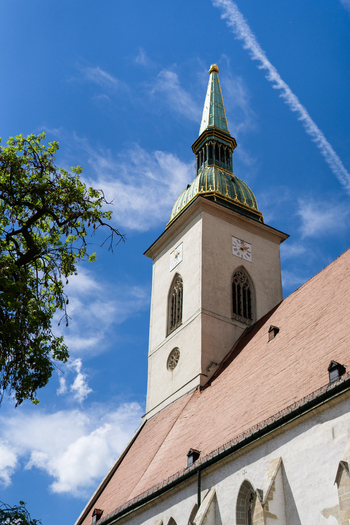 View of the historic St. Martin s Cathedral with its iconic green spire and red tiled roof under a clear blue sky in Bratislava Bratislava Region Slovakia. View of the historic St. Martin s Cathedral with its iconic green spire and red tiled roof under a clear blue sky in Bratislava Bratislava Region Slovakia.