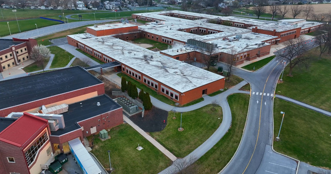 Aerial view of the Derry Township school complex with its expansive red brick buildings flat roofs surrounding green lawns and paved access roads in Hershey Pennsylvania United States. Aerial view of the Derry Township school complex with its expansive red brick buildings flat roofs surrounding green lawns and paved access roads in Hershey Pennsylvania United States.
